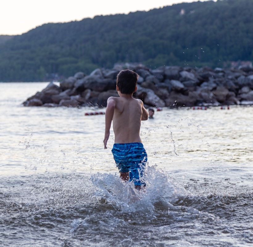 A child running into the water at the Deep Creek Lake beach